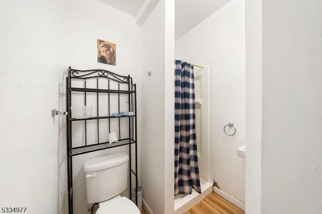 bathroom with walk in shower, toilet, and hardwood / wood-style flooring