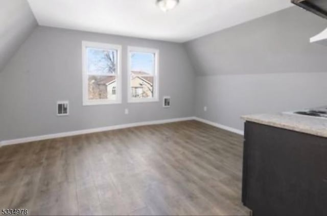 bonus room featuring wood-type flooring and vaulted ceiling