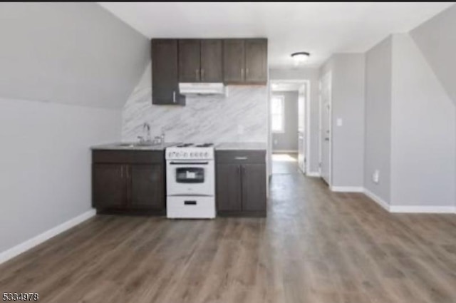 kitchen featuring sink, backsplash, white electric range oven, dark brown cabinetry, and wood-type flooring