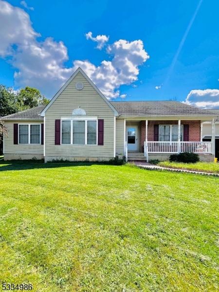 ranch-style house with covered porch and a front yard