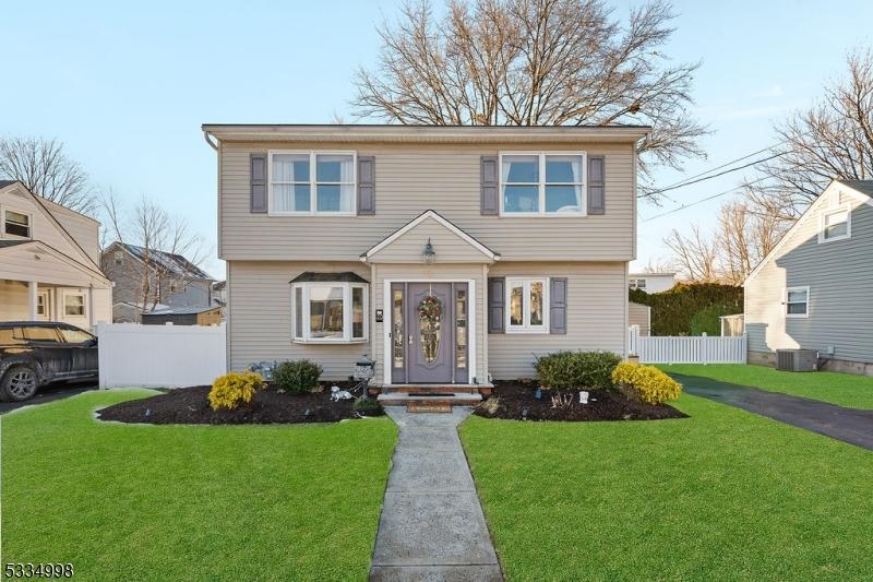 front of property with cooling unit and a front lawn