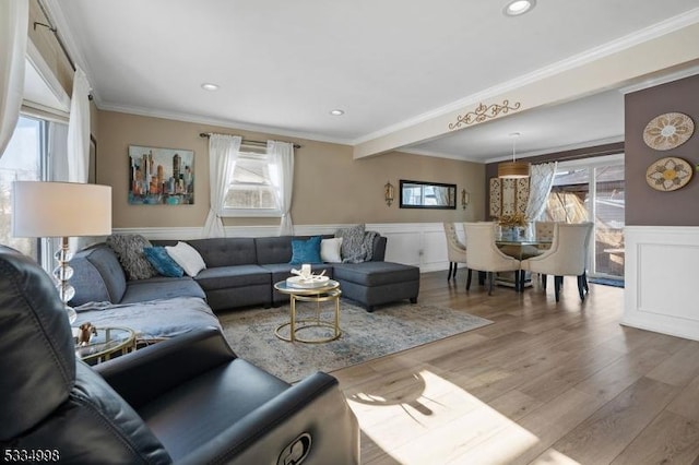 living room with hardwood / wood-style flooring, plenty of natural light, and ornamental molding