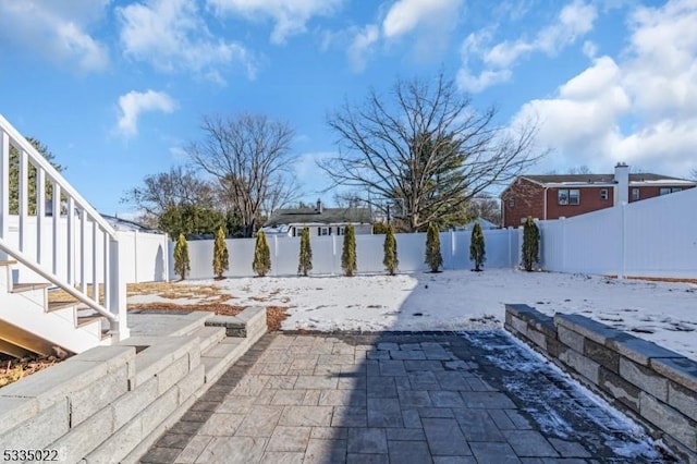 yard covered in snow featuring a patio