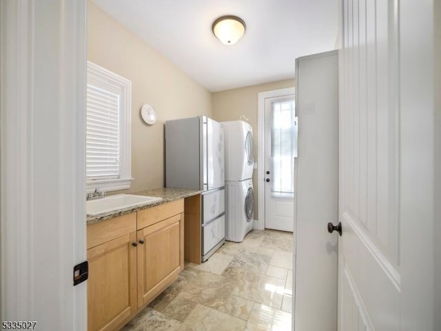 interior space with vanity and stacked washer and dryer