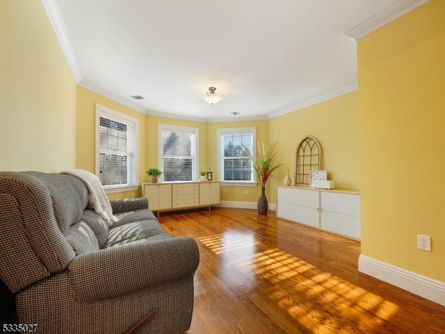 living area with crown molding and hardwood / wood-style flooring