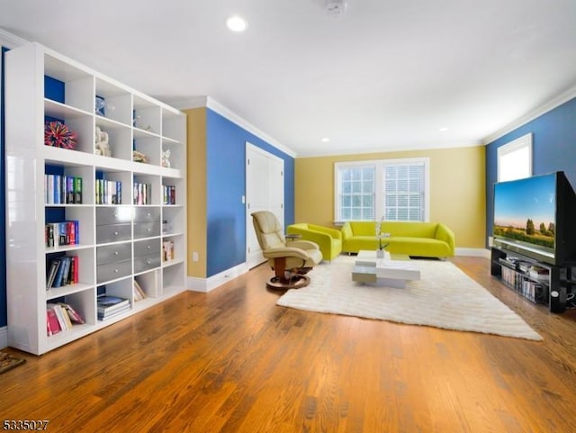 living area with crown molding and wood-type flooring