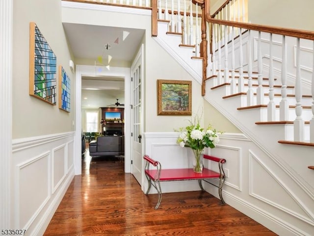 staircase with wood-type flooring and ceiling fan