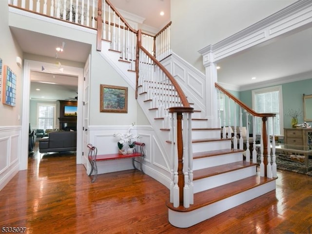 staircase with ornamental molding and hardwood / wood-style floors