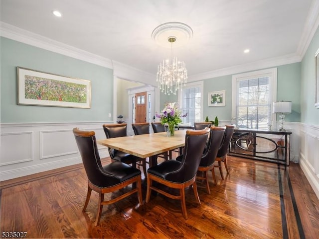 dining area featuring wood-type flooring, a chandelier, and crown molding