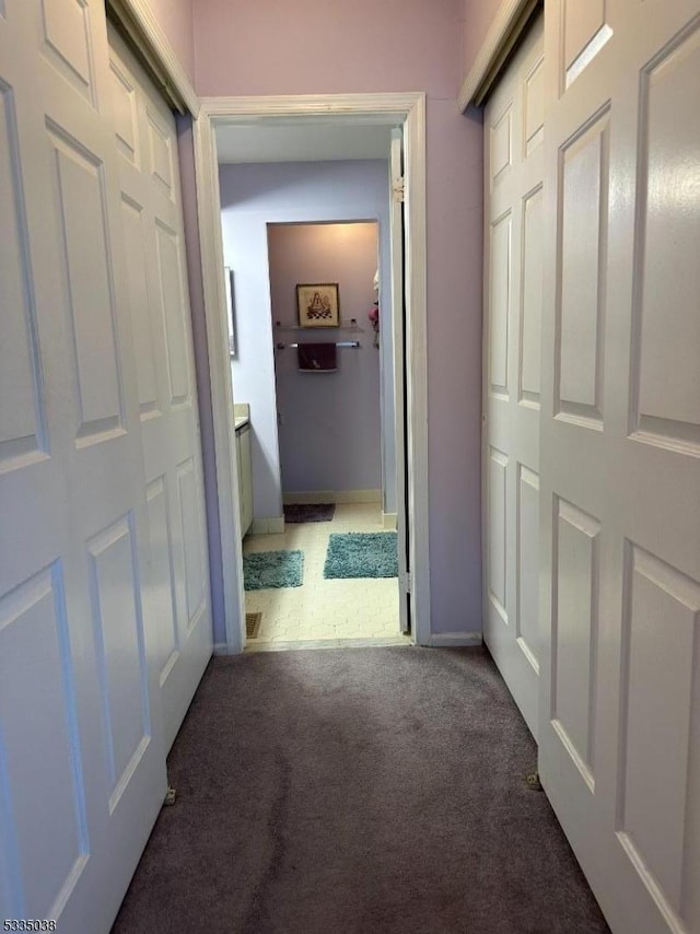 hall with dark colored carpet