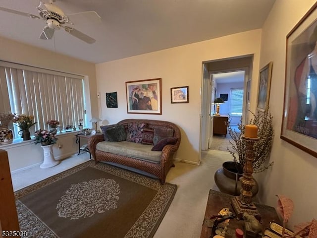 carpeted living room with ceiling fan