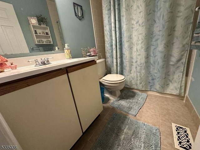 bathroom with vanity, tile patterned flooring, toilet, and walk in shower