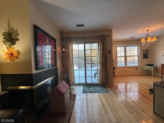 doorway featuring a notable chandelier and light wood-type flooring