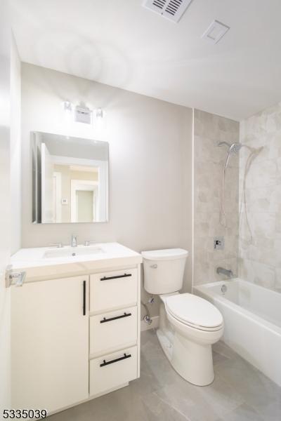 full bathroom featuring vanity, toilet, and tiled shower / bath