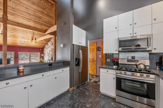 kitchen featuring stainless steel appliances, dark countertops, wood ceiling, and white cabinetry