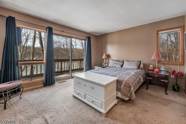 bedroom with access to outside, visible vents, and light colored carpet