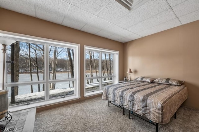 carpeted bedroom with a drop ceiling