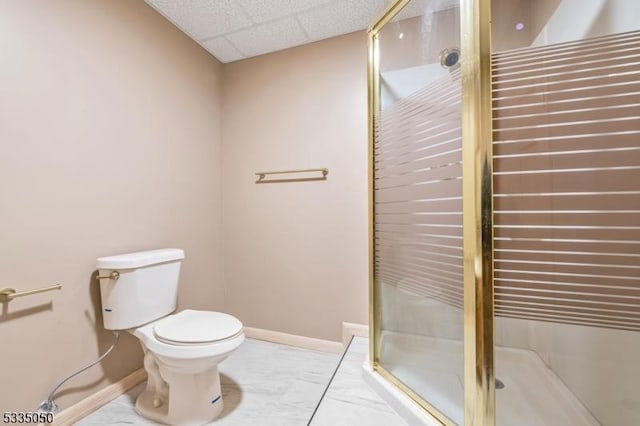 full bathroom with a paneled ceiling, a stall shower, toilet, and baseboards