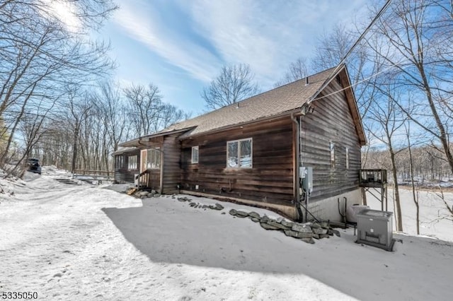 view of snowy exterior with a shingled roof