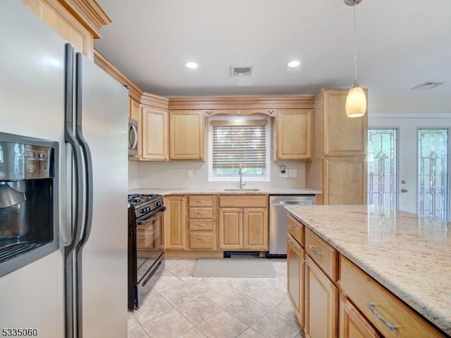 kitchen with sink, appliances with stainless steel finishes, light stone countertops, decorative light fixtures, and light brown cabinets