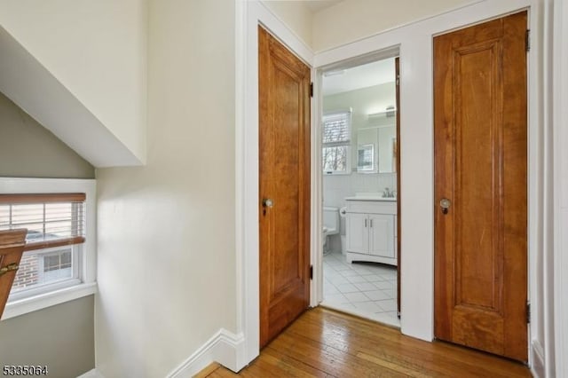 hall featuring a sink and hardwood / wood-style flooring