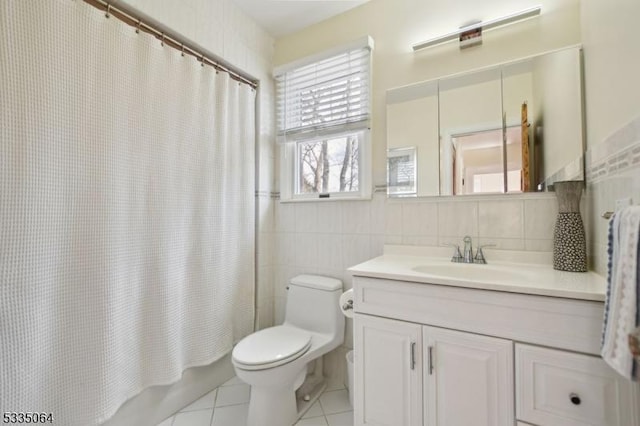 bathroom with toilet, vanity, tile walls, tile patterned floors, and shower / bath combo with shower curtain