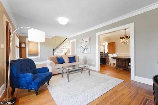 living area featuring baseboards, stairway, light wood-type flooring, and crown molding