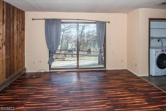 interior space with washer / dryer, baseboards, baseboard heating, and wood finished floors