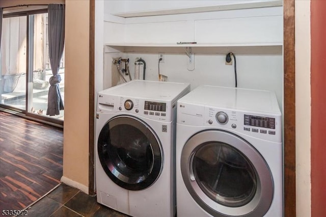 washroom featuring laundry area, independent washer and dryer, and dark tile patterned floors