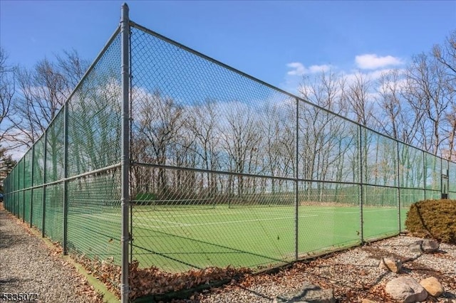 view of tennis court featuring fence