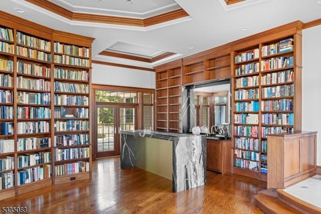 office area with french doors, hardwood / wood-style flooring, ornamental molding, a tray ceiling, and built in shelves