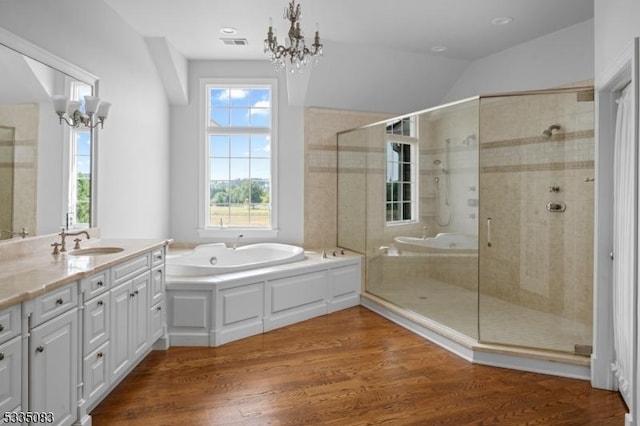 bathroom featuring wood-type flooring, shower with separate bathtub, a notable chandelier, and vanity