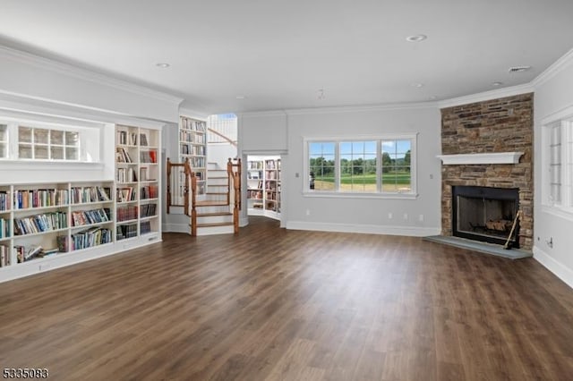 unfurnished living room with dark hardwood / wood-style flooring, crown molding, and a stone fireplace