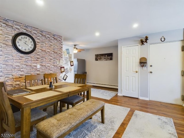 dining space with baseboard heating, ceiling fan, and hardwood / wood-style floors