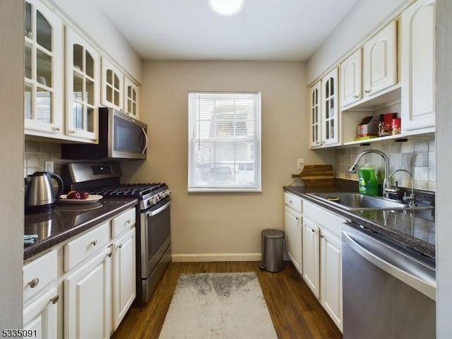 kitchen featuring stainless steel appliances, white cabinetry, sink, and dark hardwood / wood-style flooring