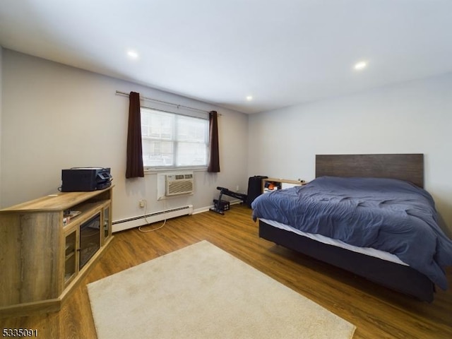 bedroom with dark hardwood / wood-style flooring, a wall mounted air conditioner, and a baseboard radiator