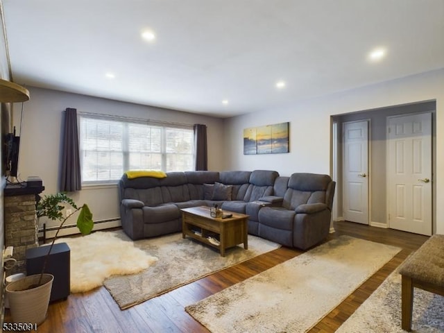 living room featuring a fireplace, dark wood-type flooring, and baseboard heating