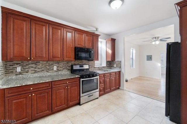 kitchen with black appliances, sink, decorative backsplash, light stone counters, and ceiling fan