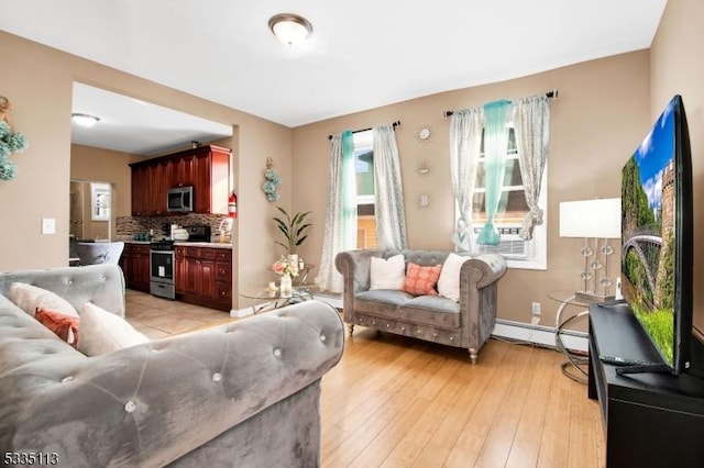 living room with cooling unit, a baseboard heating unit, and light wood-type flooring