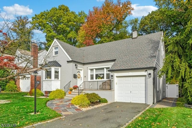 view of property with a garage and a front lawn