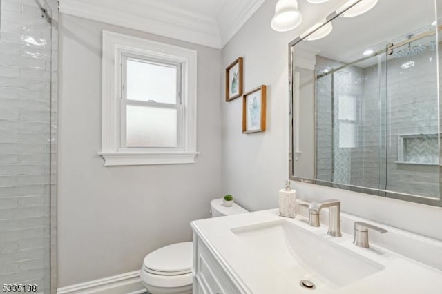 bathroom with vanity, ornamental molding, a shower with door, and toilet