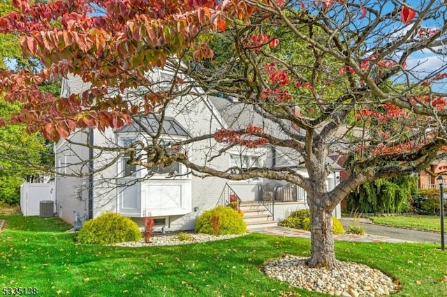 view of side of home featuring central AC and a yard