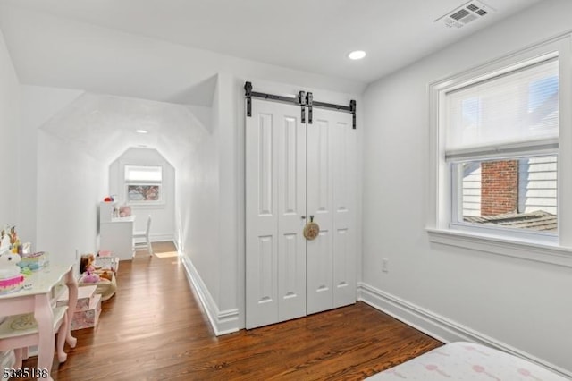 interior space featuring a barn door and dark hardwood / wood-style floors