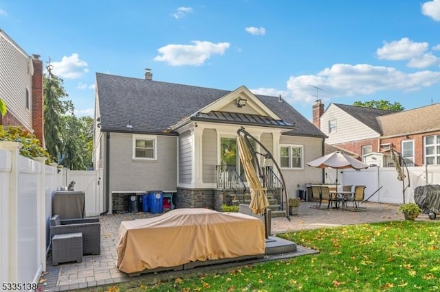 rear view of house with a patio and a lawn