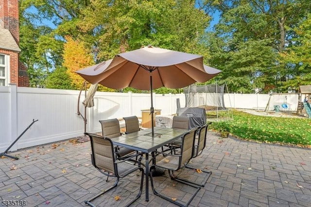 view of patio / terrace featuring a trampoline, a grill, and a playground