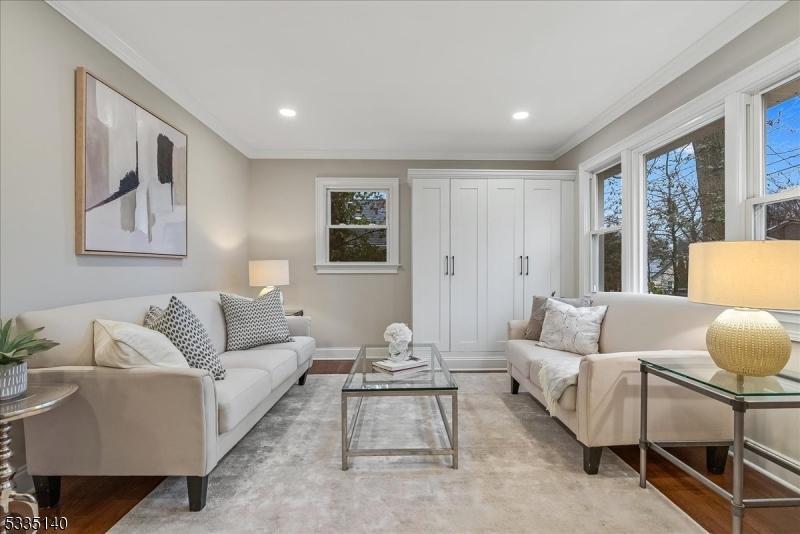 living room featuring crown molding and light hardwood / wood-style floors