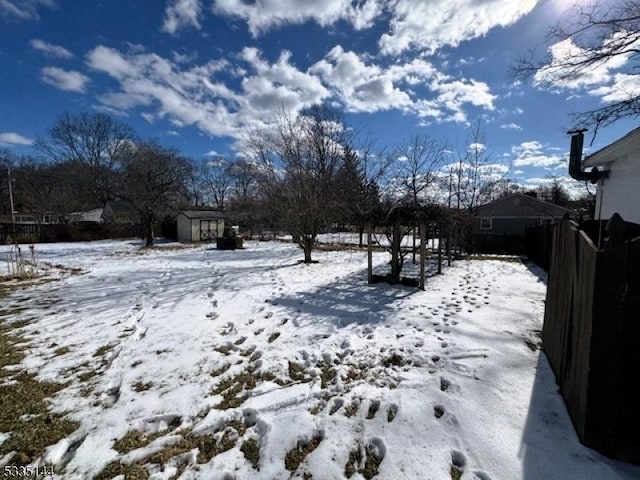 yard covered in snow featuring a storage unit