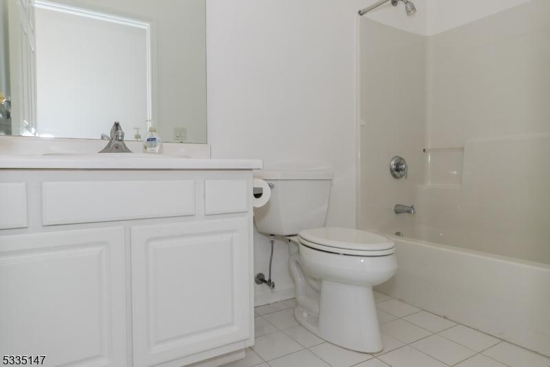 full bathroom featuring tile patterned flooring, vanity, shower / tub combination, and toilet