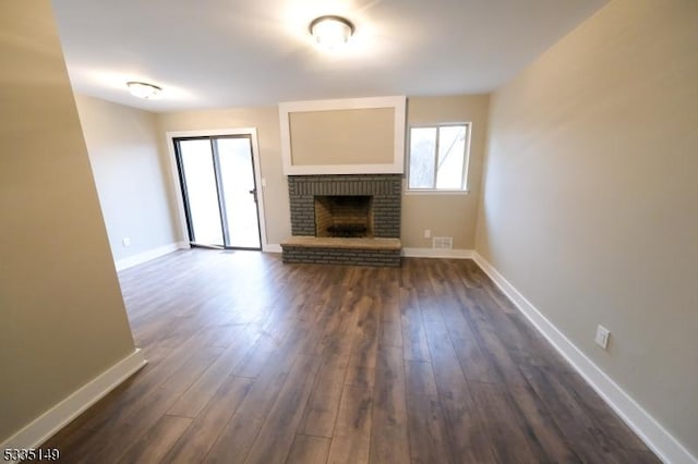 unfurnished living room featuring a fireplace and dark wood-type flooring