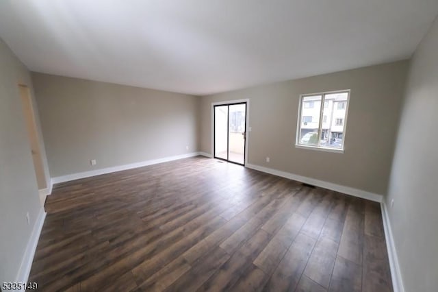 unfurnished room featuring dark wood-type flooring